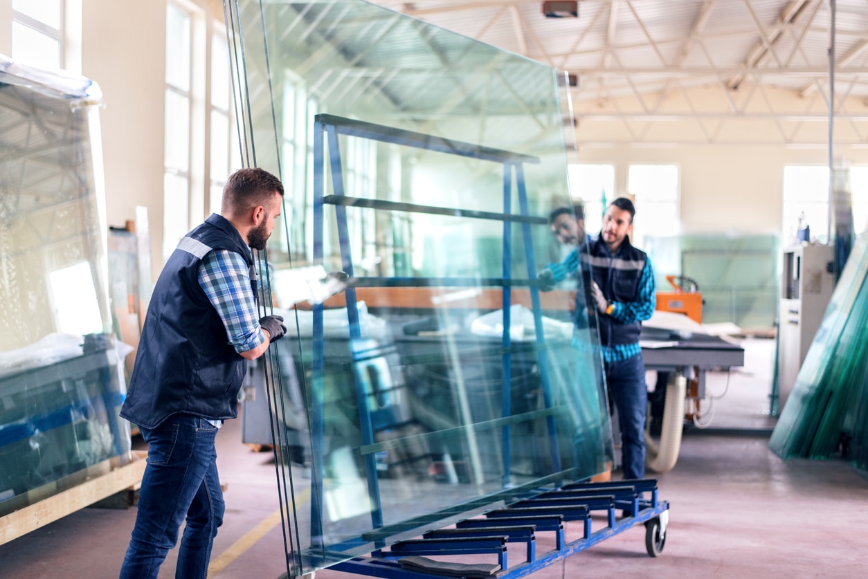 workers packaging glass sheets in warehouse